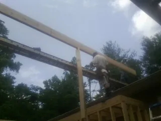 Carpenter setting a ridge beam over a new addition frame — Ice Dam Removal by Roofing Brothers in Bonduel