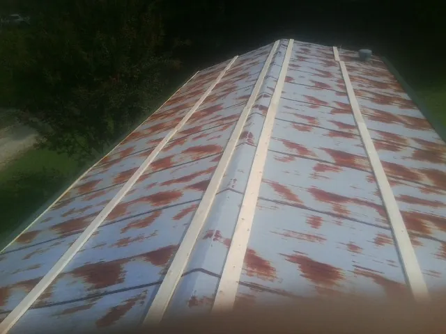 Rusted metal roof panels with new wood purlins before replacement — Storm Damage Roof Repair in Bonduel by Roofing Brothers